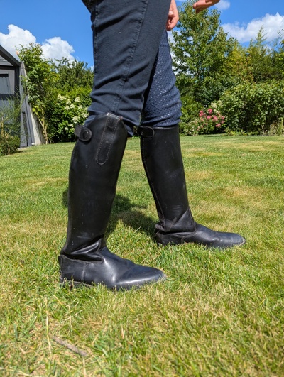Schwarze Reitstiefel an einem Kind